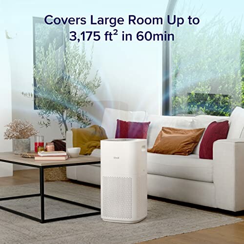 Air purifier in a living room with a couch and plants.
